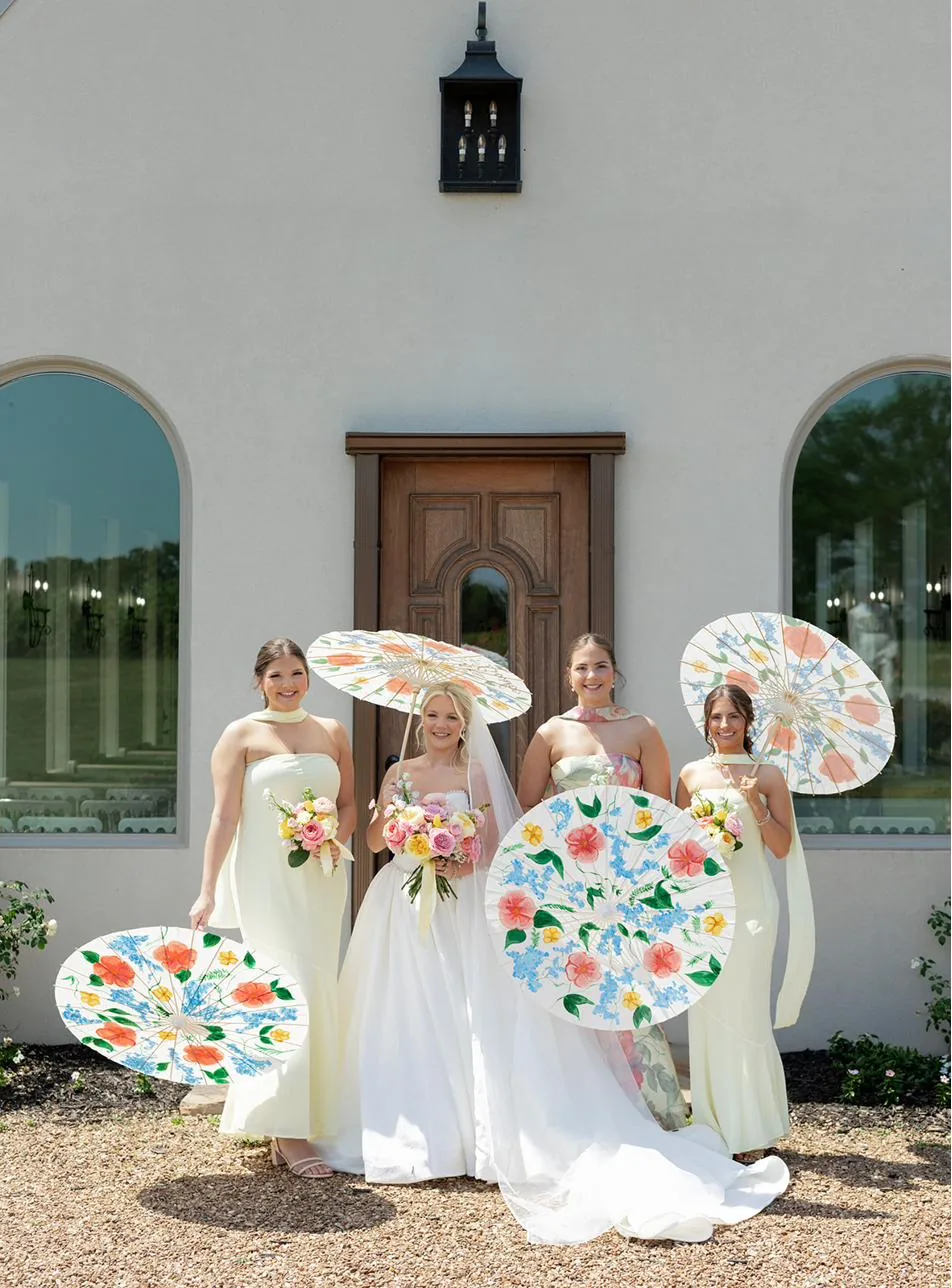 The wedding party with parasols before the second line at Gateley Hill Gardens