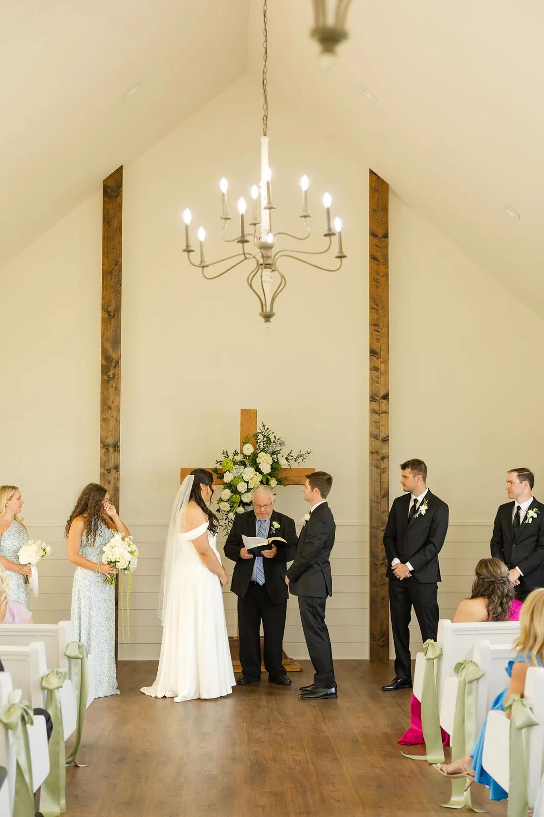 Jennifer and Hayden exchanging vows in the white chapel at Gateley Hill Gardens