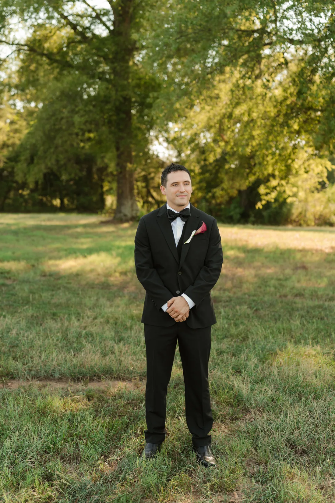 Sam in his black tux in the field at Gateley Hill Gardens