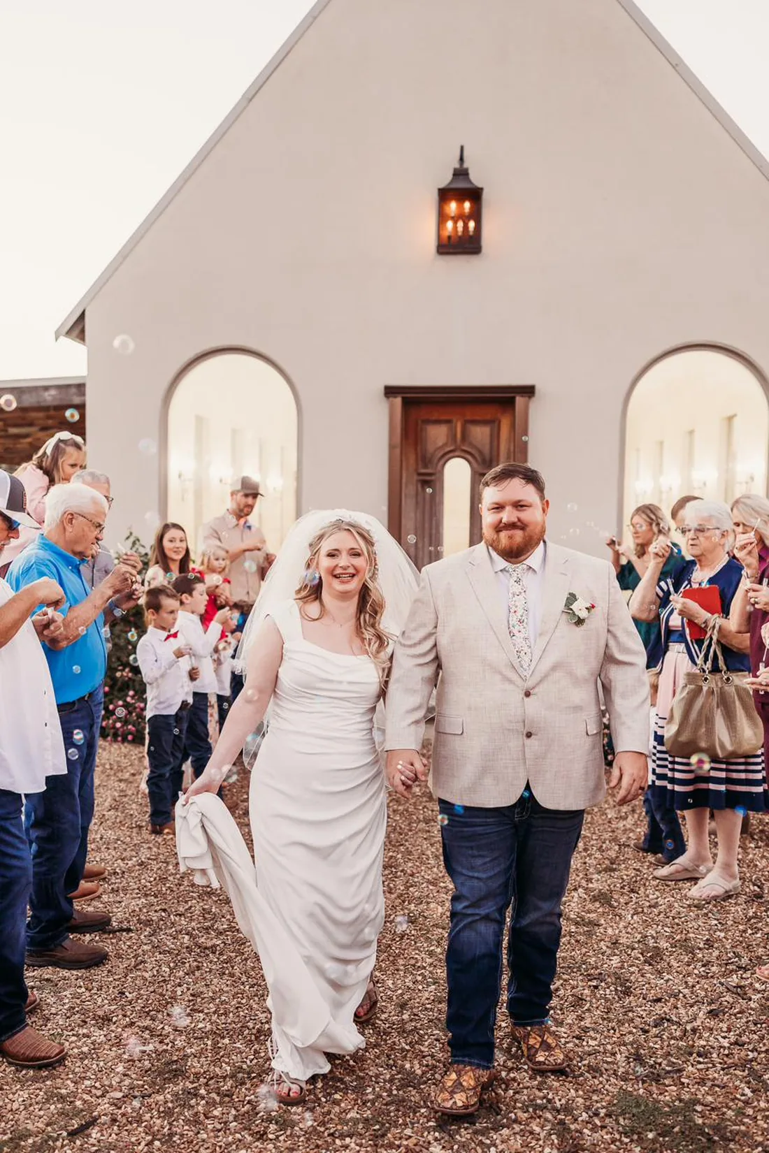 Couple leaving their fall wedding in warm amber light at Gateley Hill Gardens