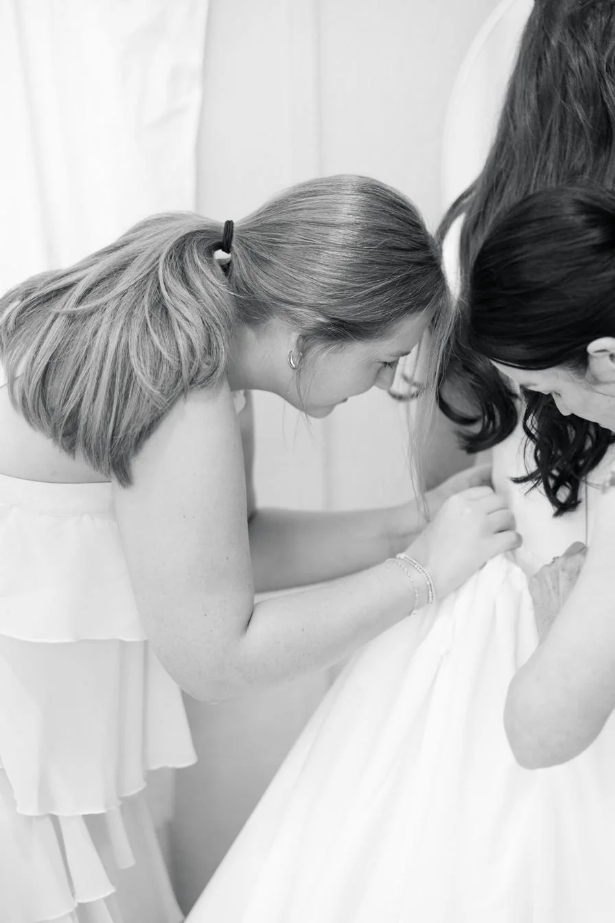 Sisters helping with the gown